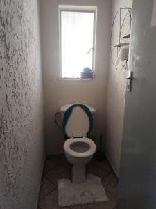 a small bathroom with a toilet with a window at Soshanguve Lux Accom Room 02 in Soshanguve
