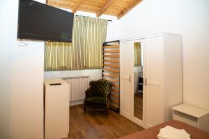 a room with a tv and a chair in a room at Affittacamere il vecchio fienile in Ameglia