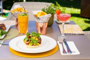 a table with a plate of food and a drink at Waldorf Astoria Versailles - Trianon Palace in Versailles +141 photos