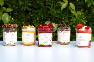 a group of four jars of jam with strawberries in them at Waldorf Astoria Versailles - Trianon Palace in Versailles
