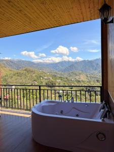 a bath tub sitting on a balcony with a view at Villa Kapreshumi in Itʼkhvisi +5 photos