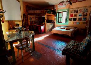 a room with a bed and a table and a kitchen at Krasberry Ježev brlog in Komen
