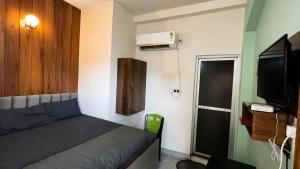a small room with a bed and a television at Residence Inn in Patna
