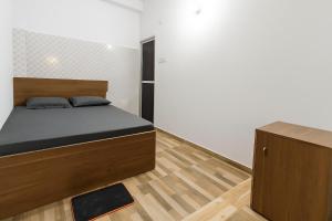 a small bedroom with a bed and a cabinet at Residence Inn in Patna +2 photos