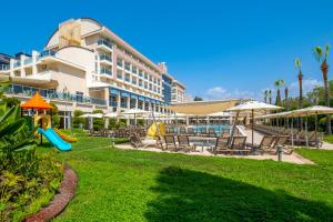 a resort with a slide and chairs and a playground at Solivia hotel in Alanya