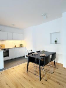 a kitchen and dining room with a black table and chairs at Feigenterrasse beim Semmering - Studio in Schlagl +5 photos