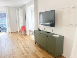 a living room with a flat screen tv on a wall at Feigenterrasse beim Semmering - Studio in Schlagl