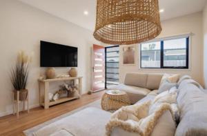 a living room with a couch and a tv at Seaside Luxe at Vila Morava in Rosebud +29 photos