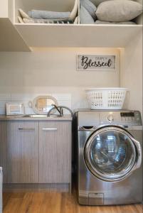 a washer and dryer in a laundry room with a sink at Seaside Luxe at Vila Morava in Rosebud