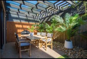 a patio with a table and chairs under a pergola at Seaside Luxe at Vila Morava in Rosebud