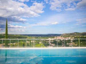 a swimming pool with a view of a city at gite villa ardeche joyeuse piscine in Joyeuse