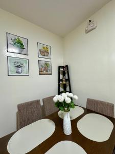 a dining room table with a vase of flowers on it at Te Haven in Davao City