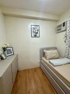 a small bedroom with a bed and a desk at Te Haven in Davao City