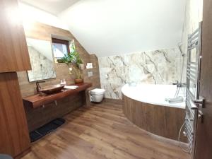 a bathroom with a large tub and a sink at Apartmánový Dom Terchová in Terchová +39 photos