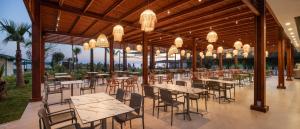 a restaurant with tables and chairs and chandeliers at Solivia hotel in Alanya