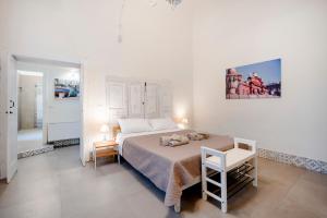 a white bedroom with a bed and a bathroom at Garibaldi 54 in Bari
