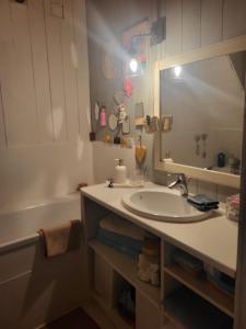 a bathroom with a sink and a tub and a mirror at Échoppe Saint Augustin in Bordeaux
