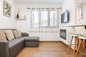 a living room with a couch and a tv at Relax en Pirineo l Vistas l Wifi l Balcón in Panticosa