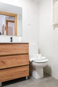 a bathroom with a toilet and a sink and a mirror at Relax en Pirineo l Vistas l Wifi l Balcón in Panticosa