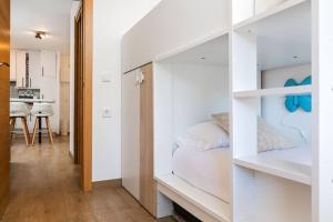 a small bedroom with white walls and a bunk bed at Relax en Pirineo l Vistas l Wifi l Balcón in Panticosa