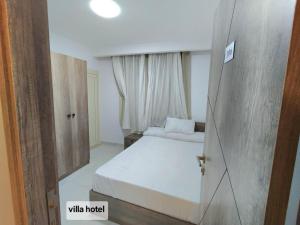 a small bedroom with a bed and ajar door at new Villa117 in Cairo