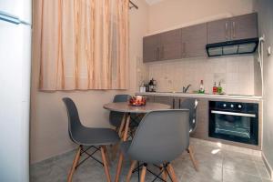 a kitchen with a table and chairs in a kitchen at Seaside Plitra Paradiso - Steps from the Beach in Plytra