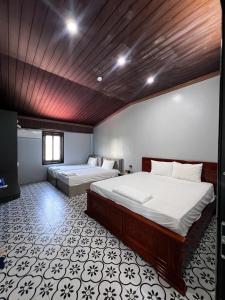 a bedroom with two beds and a wooden ceiling at Bông Phố Cổ Homestay in Ninh Binh