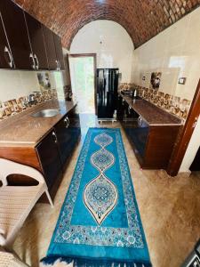 a kitchen with a blue rug with a clock on it at Dara guest House in Aswan