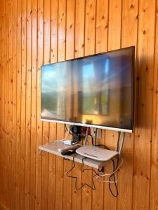 a flat screen tv hanging on a wooden wall at Villa Kapreshumi in Itʼkhvisi