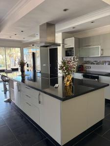 a large kitchen with a large island with black counter tops at Les Villas du Douar in Azib Oulad Lâdem