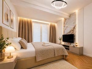 a bedroom with a large bed and a television at Ceglana Apart 01A in Katowice