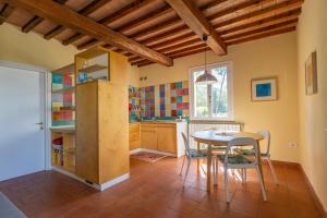 a kitchen with a table and chairs in a room at Piccolo Paradiso - Riparbella in Riparbella