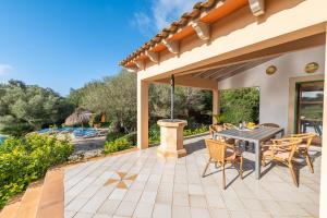 a patio with a table and chairs and a pool at Finca Binifarda by Mallorca House Rent in Felanitx