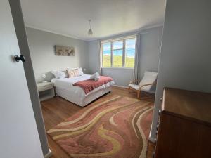 a small bedroom with a bed and a window at Tyne above Town in Oamaru