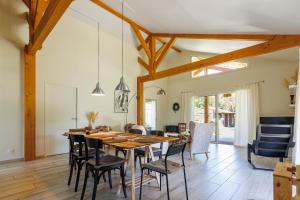 a dining room with a wooden table and chairs at Océan Alegria – Conciergerieland in Léon
