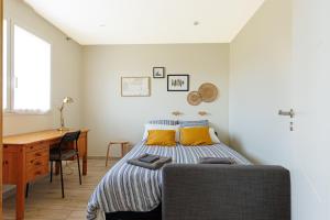 a bedroom with a bed with yellow pillows and a desk at Océan Alegria – Conciergerieland in Léon