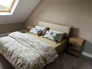 a bedroom with a bed with pillows and a window at The loft in Tingewick