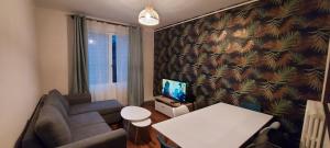 a small living room with a couch and a television at Dieppe plage à 2min à pied in Dieppe