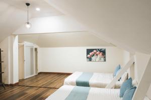 a white room with two beds and a staircase at StayDalat in Ấp Ða Lợi