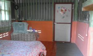 a bedroom with a bed and a door with a refrigerator at Baan Pai Likit in Pai +31 photos