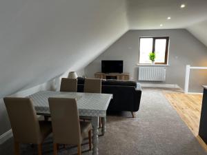 a living room with a table and chairs and a television at The loft in Tingewick
