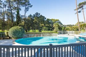 a swimming pool with a fence around it at Entre Foret et Ocean in Moliets-et-Maa