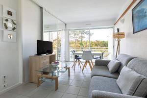 a living room with a couch and a tv and a table at Entre Foret et Ocean in Moliets-et-Maa