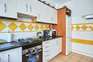 a kitchen with white cabinets and a black counter top at Casa Emilia in Baeza