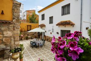 a courtyard with a table and purple flowers at Casa Emilia in Baeza