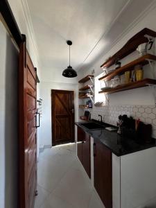 a kitchen with a black counter top and a door at The Cozy Cottage in Ndola