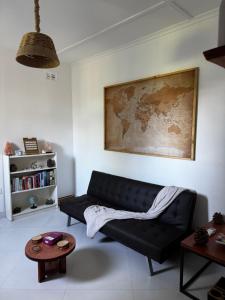 a living room with a black couch and a table at The Cozy Cottage in Ndola