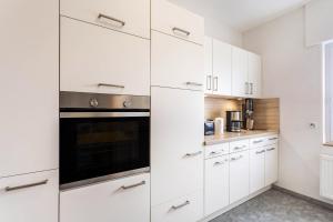 a kitchen with white cabinets and a black oven at Ferienwohnung Gerke in Warstein
