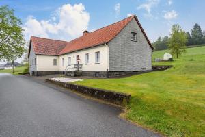 a white house with a red roof on the side of a road at Ferienwohnung Gerke in Warstein
