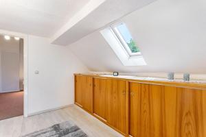 an attic kitchen with a skylight and wooden cabinets at Ferienwohnung Gerke in Warstein +27 photos